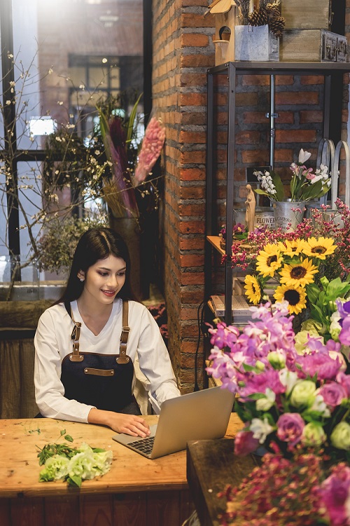 Florista con ordenador Florista gestionando pedidos online