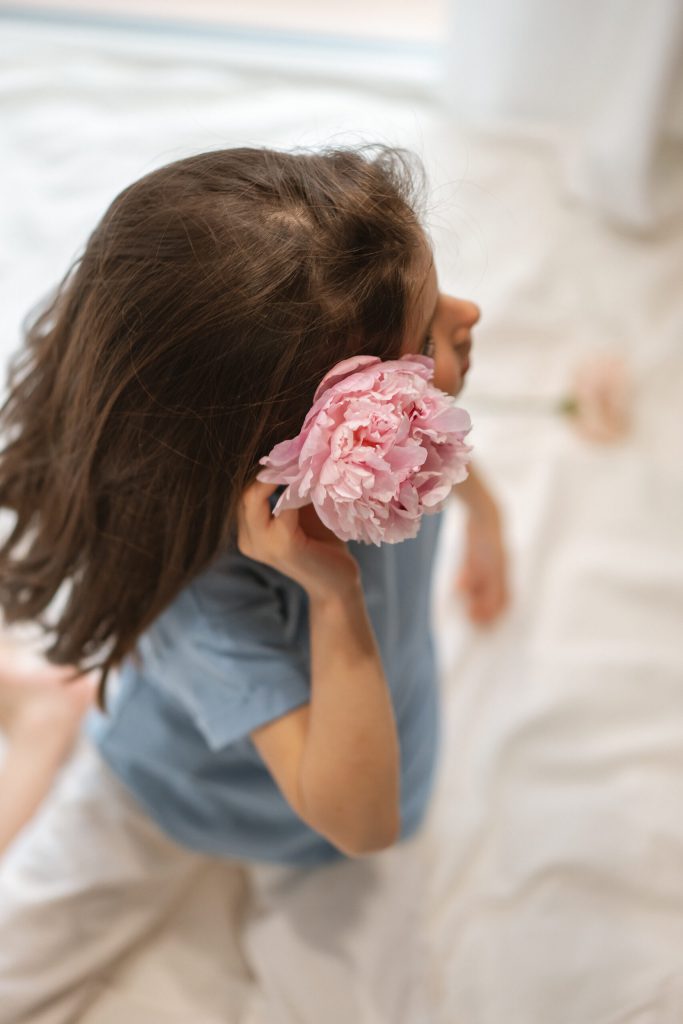 Una niña con una peonía