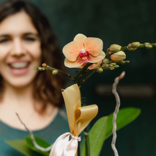 Una mujer recibe una orquídea