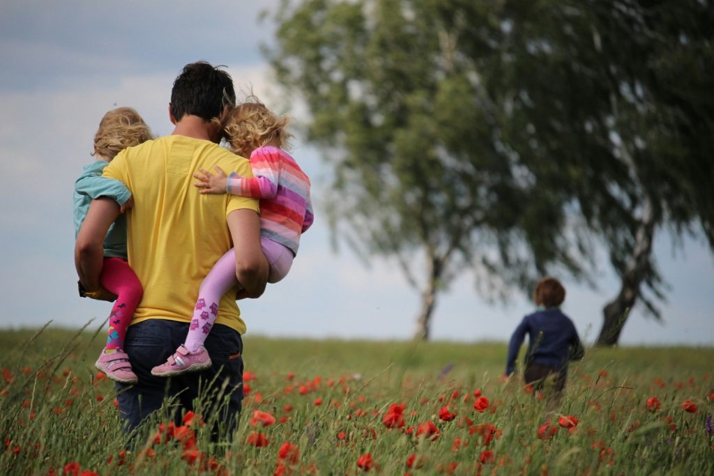 Père et ses enfants dans un champs de fleurs