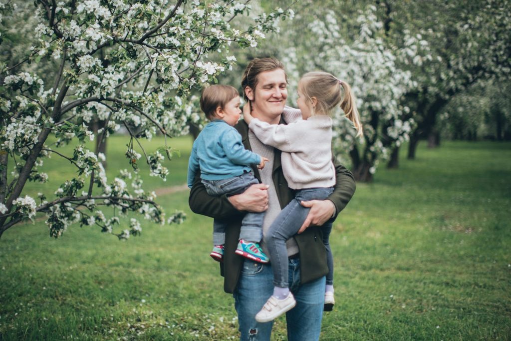 père qui porte ses enfants sourire