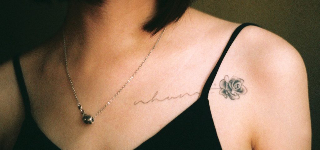 Tatuaje flor y letras mujer