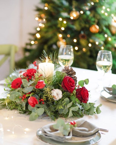 Arreglos florales de Navidad en servicios de mesa, sillas y regalos