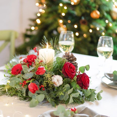 Arreglos florales de Navidad en servicios de mesa, sillas y regalos